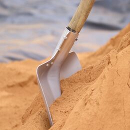 Eine Schaufel in einem Sandhaufen